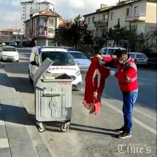 Çöpte gördüğü Türk bayrağını temizledikten sonra aracına aldı